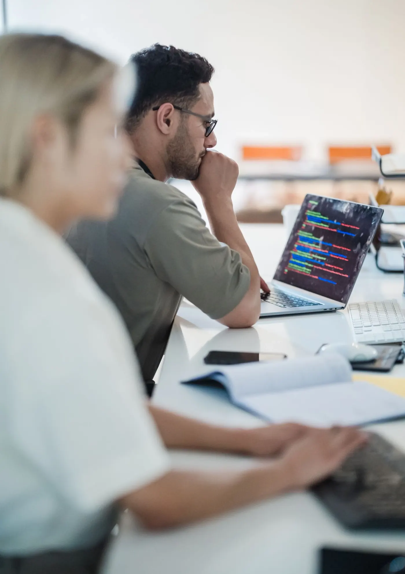 A developer working through code on a laptop at an office desk